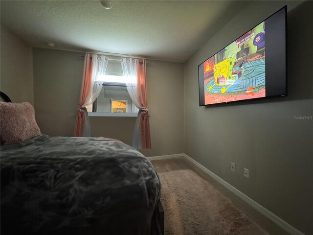 bedroom featuring carpet flooring and a textured ceiling