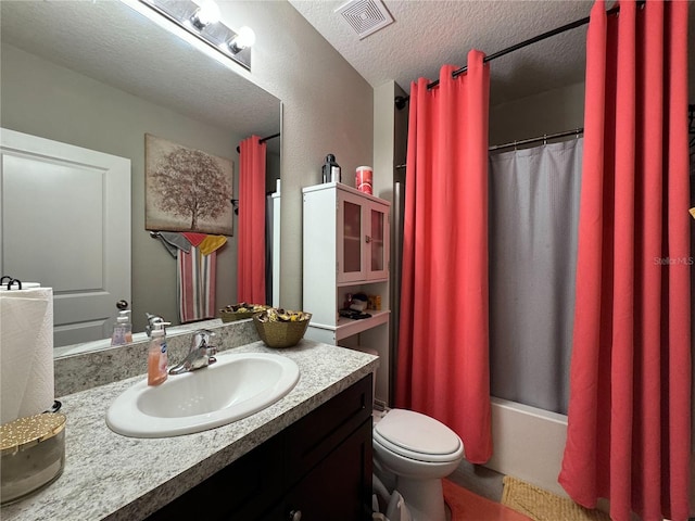 full bathroom with vanity, toilet, shower / bath combo, and a textured ceiling