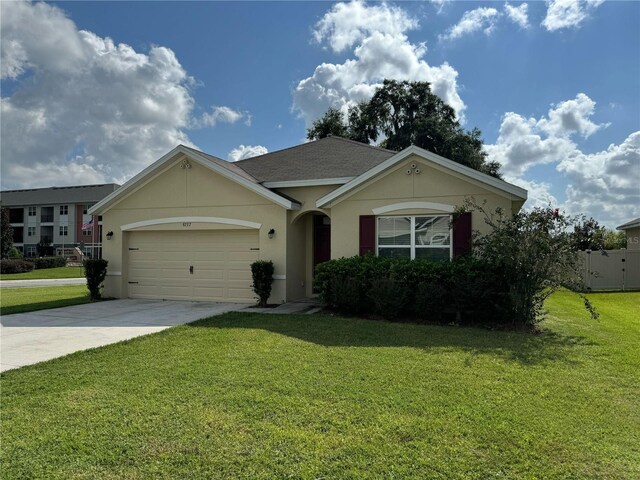 ranch-style home with a garage and a front lawn