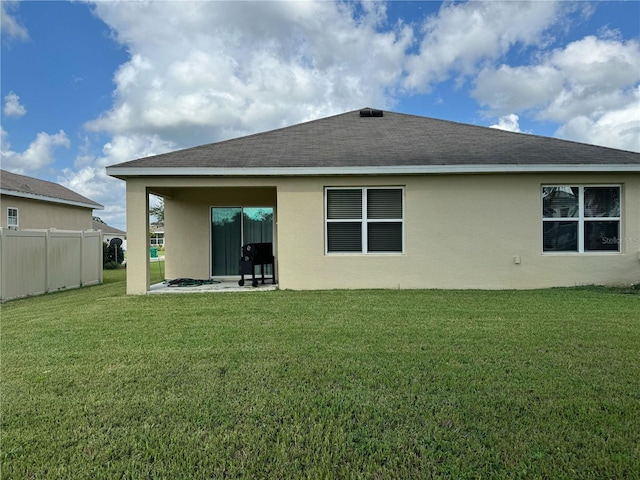 rear view of property with a lawn and a patio