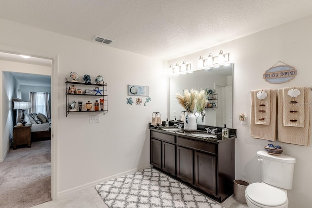 bathroom with vanity, tile patterned floors, a textured ceiling, and toilet