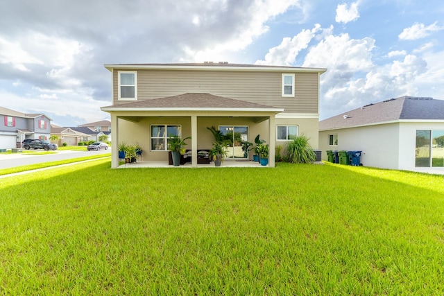 rear view of property featuring a lawn and a patio