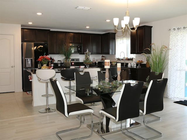 dining space featuring light hardwood / wood-style floors and a chandelier