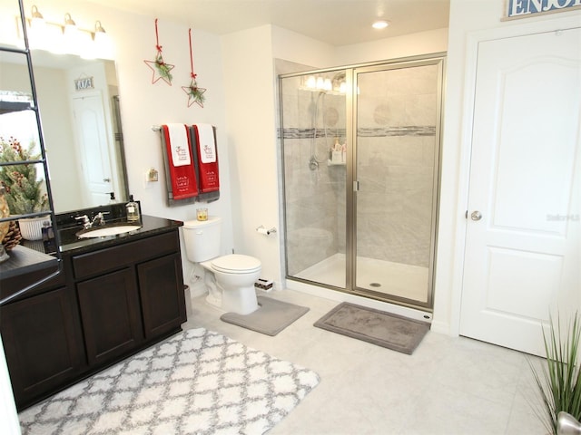 bathroom featuring vanity, toilet, and a shower with door