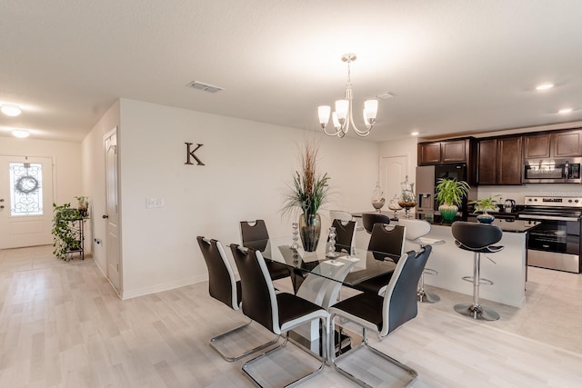 dining room with a notable chandelier and light hardwood / wood-style floors