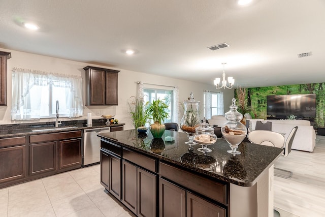 kitchen featuring dark brown cabinetry, dishwasher, sink, dark stone countertops, and a chandelier