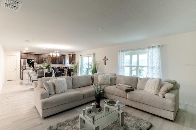 living room featuring a chandelier and light hardwood / wood-style floors