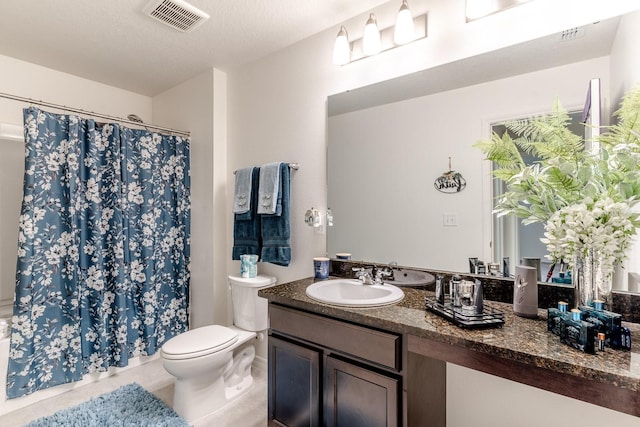 bathroom with tile patterned floors, a textured ceiling, vanity, toilet, and curtained shower