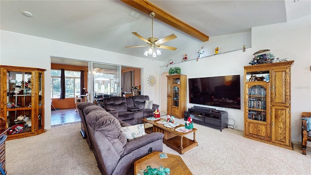 carpeted living room with ceiling fan and lofted ceiling with beams