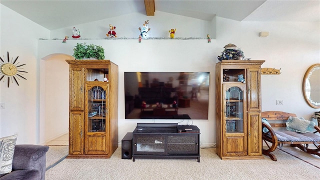 carpeted living room with lofted ceiling with beams