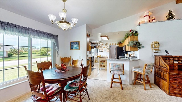 dining space featuring a notable chandelier, light tile patterned flooring, vaulted ceiling, and a healthy amount of sunlight