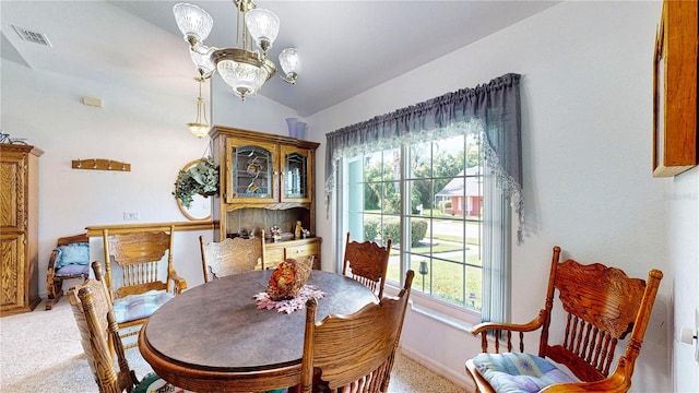 dining area with vaulted ceiling, carpet flooring, plenty of natural light, and a chandelier