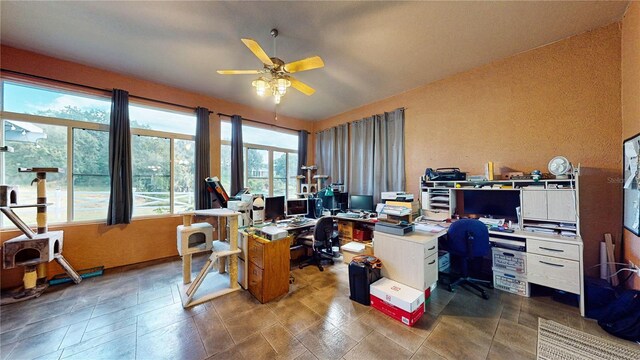 tiled office space featuring ceiling fan