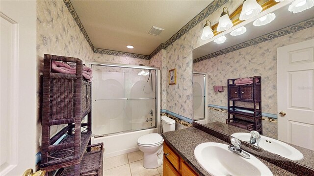 full bathroom with shower / bath combination with glass door, toilet, vanity, and tile patterned floors