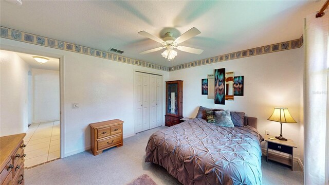 carpeted bedroom with ceiling fan and a closet