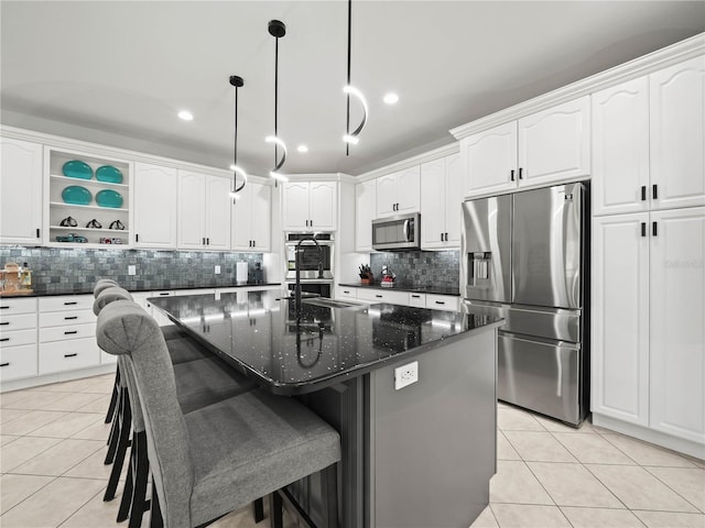 kitchen featuring a center island with sink, appliances with stainless steel finishes, and white cabinetry