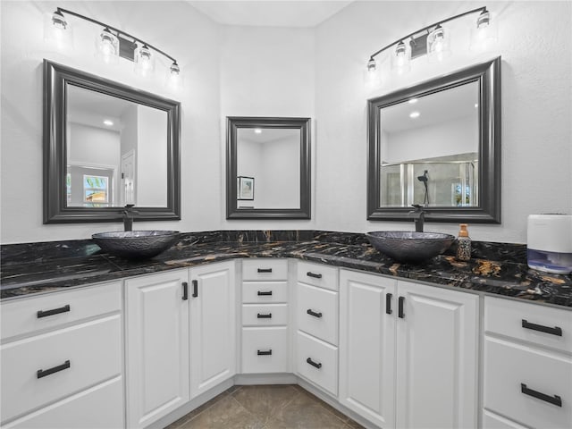 bathroom with tile patterned flooring, vanity, and a shower with shower door