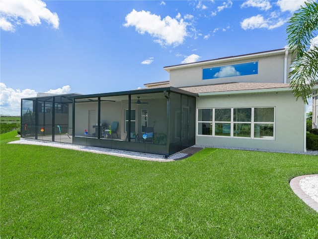 rear view of house featuring a yard, ceiling fan, and a sunroom