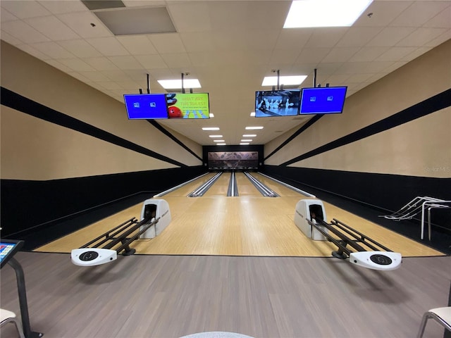 playroom featuring bowling, wood-type flooring, and a drop ceiling