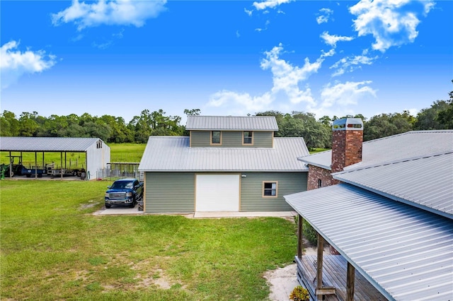 back of house with a yard, a chimney, metal roof, a garage, and driveway