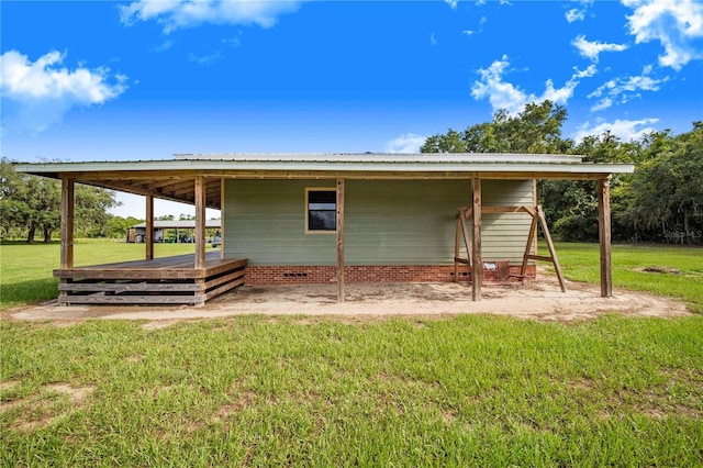 exterior space with metal roof and a yard