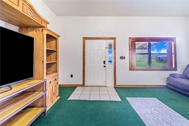 foyer entrance featuring light tile patterned floors, baseboards, and light colored carpet