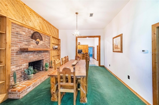 dining space with brick wall, wood walls, carpet floors, a fireplace, and an inviting chandelier