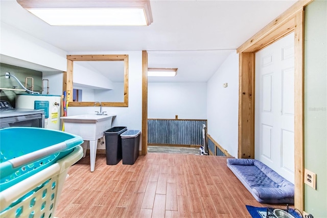 playroom with water heater and light hardwood / wood-style flooring