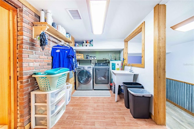 clothes washing area featuring sink and independent washer and dryer