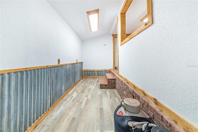 hallway featuring vaulted ceiling and wood-type flooring