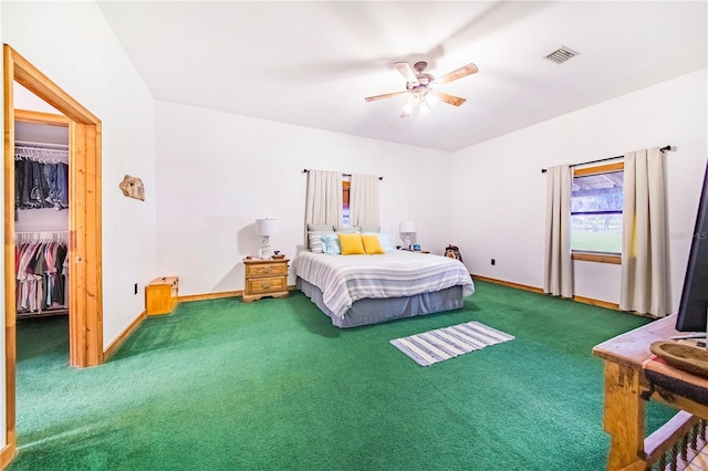 bedroom with ceiling fan, a spacious closet, a closet, and carpet flooring