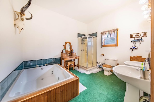 full bathroom featuring a whirlpool tub, a sink, a shower stall, and toilet