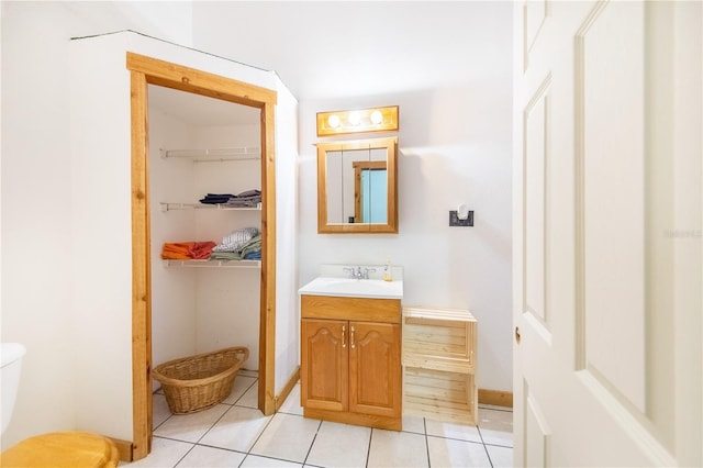 bathroom with toilet, tile patterned flooring, and vanity