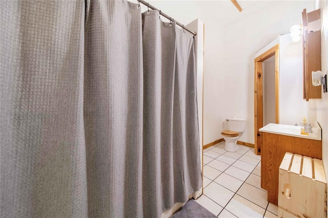 bathroom featuring toilet, tile patterned flooring, baseboards, and vanity