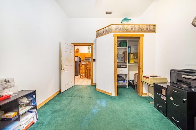 interior space with freestanding refrigerator, visible vents, and baseboards