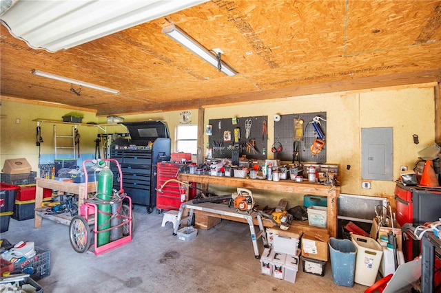 garage with a workshop area and electric panel