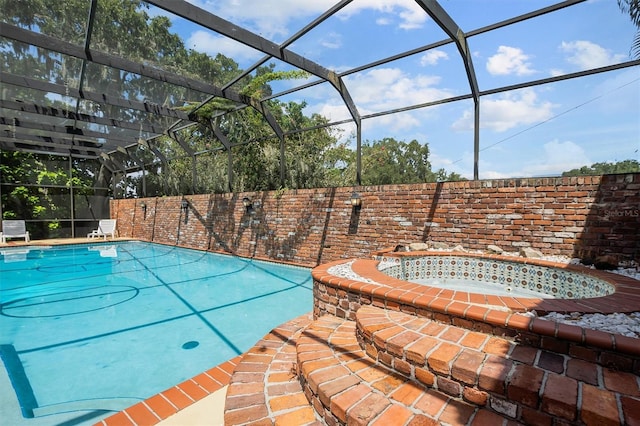 view of pool with a lanai and an in ground hot tub