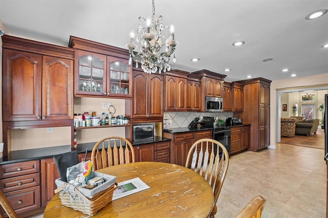 kitchen featuring tasteful backsplash, a chandelier, and electric range