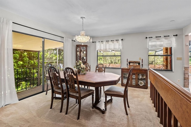 carpeted dining space with a notable chandelier