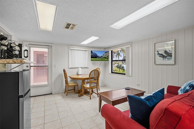 dining space with a textured ceiling and wooden walls