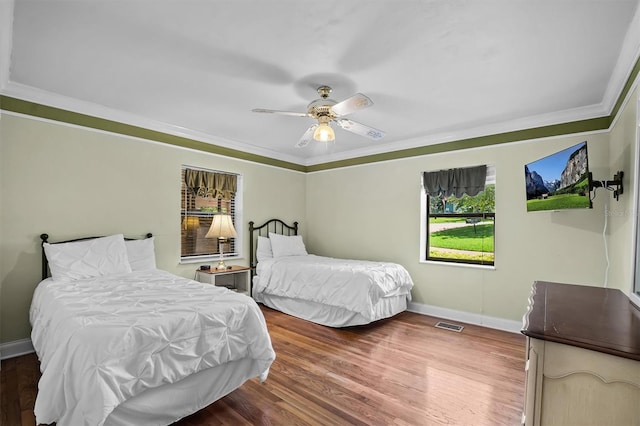 bedroom featuring crown molding, dark hardwood / wood-style flooring, and ceiling fan