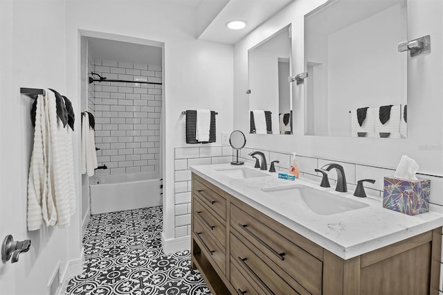 bathroom featuring tiled shower / bath and vanity