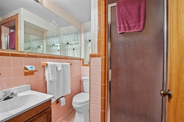 bathroom with toilet, tile patterned floors, vanity, backsplash, and tile walls