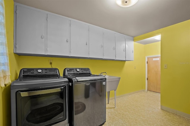 laundry area with washing machine and clothes dryer and cabinets