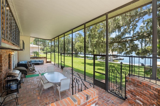 sunroom / solarium featuring a water view