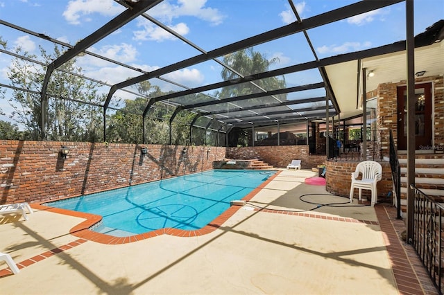 view of swimming pool with a patio area and glass enclosure