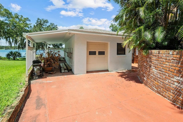 view of patio / terrace featuring a water view and a garage