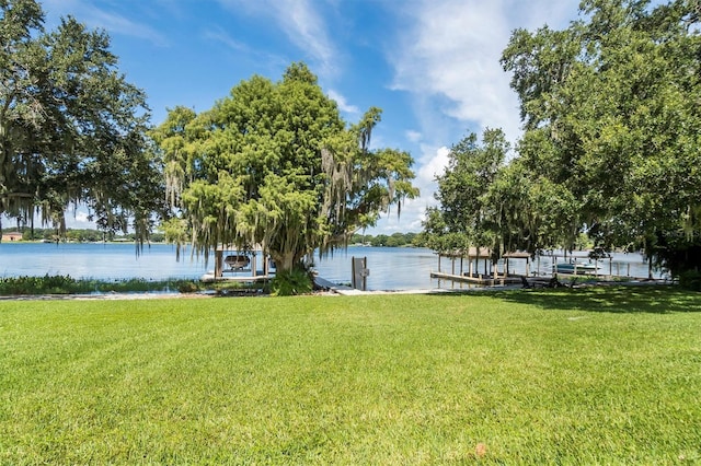 view of dock featuring a water view and a lawn