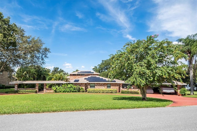 view of front of home featuring solar panels, a garage, and a front lawn