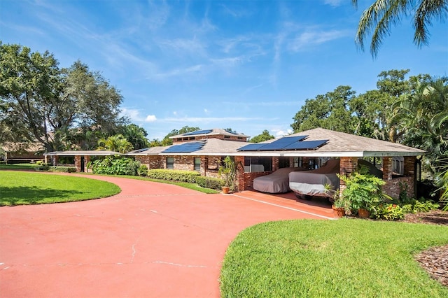 view of front of property featuring solar panels and a front yard